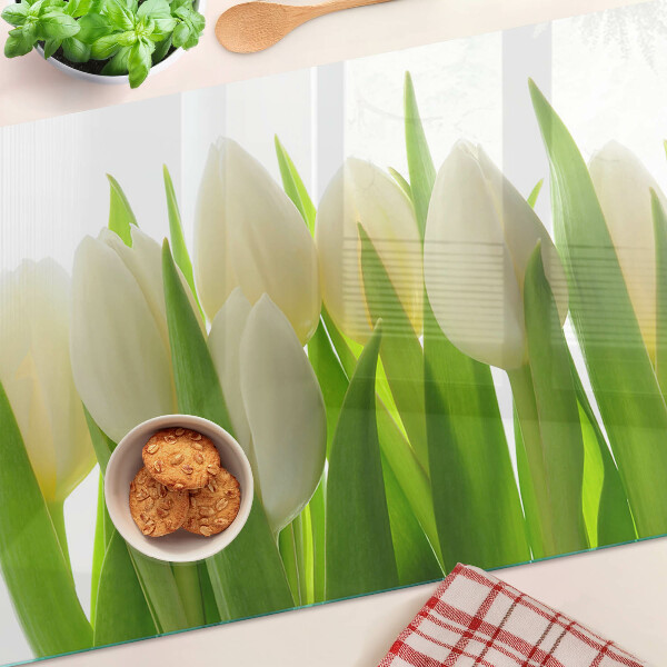 Tabla de cortar Tulipanes sobre un fondo de hojas verdes.