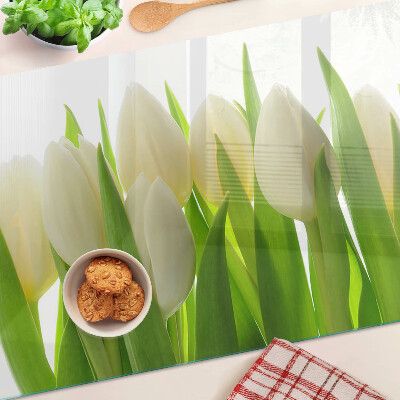 Tabla de cortar Tulipanes sobre un fondo de hojas verdes.