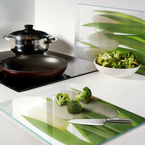 Tabla de cortar Tulipanes sobre un fondo de hojas verdes.