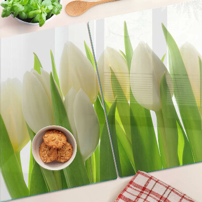 Tabla de cortar Tulipanes sobre un fondo de hojas verdes.