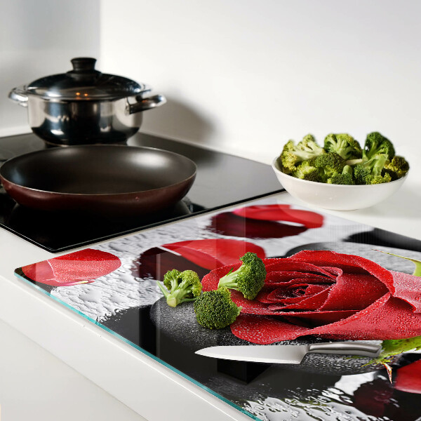 Tabla para cortar Rosa sobre piedras con gotas de agua