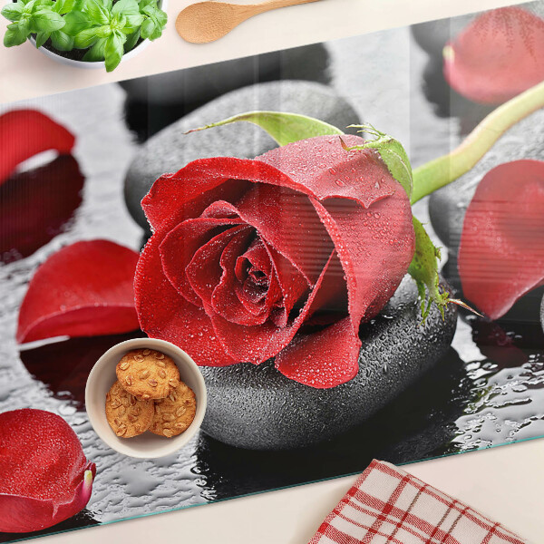 Tabla para cortar Rosa sobre piedras con gotas de agua