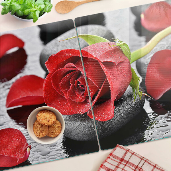 Tabla para cortar Rosa sobre piedras con gotas de agua