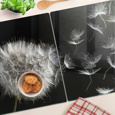 Tabla de cortar de cristal Dientes de león sobre un fondo negro