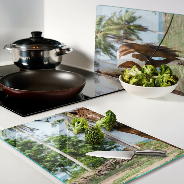 Tabla de cortar Un caballo con palmeras al fondo.