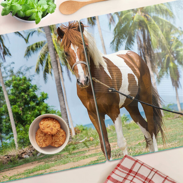 Tabla de cortar Un caballo con palmeras al fondo.