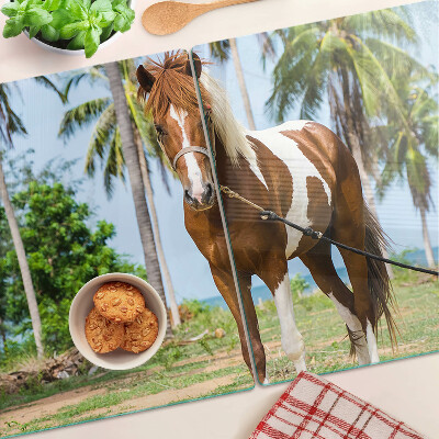 Tabla de cortar Un caballo con palmeras al fondo.