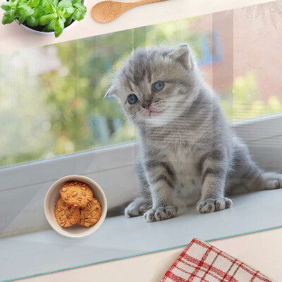 Tabla de cortar de cristal Un gatito en el alféizar de la ventana.