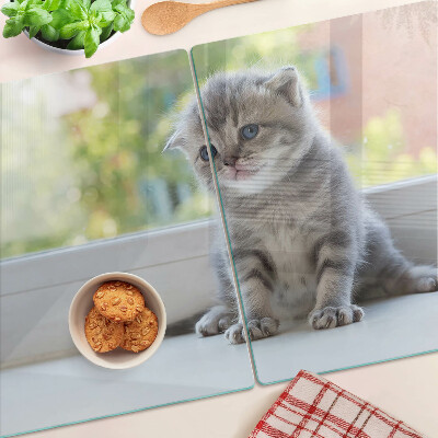 Tabla de cortar de cristal Un gatito en el alféizar de la ventana.