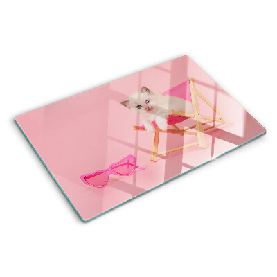 Tabla de cortar Un gatito en una tumbona sobre un fondo rosa.