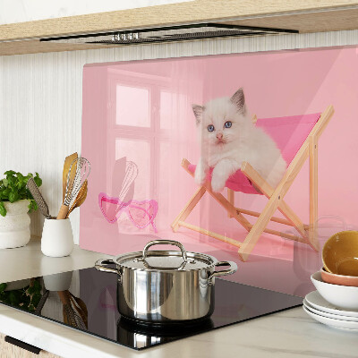 Tabla de cortar Un gatito en una tumbona sobre un fondo rosa.