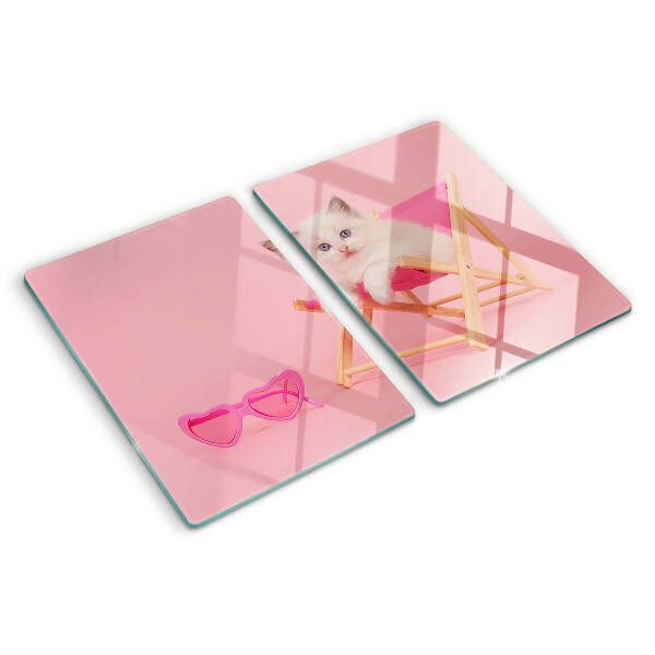Tabla de cortar Un gatito en una tumbona sobre un fondo rosa.