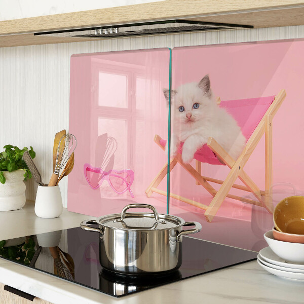 Tabla de cortar Un gatito en una tumbona sobre un fondo rosa.