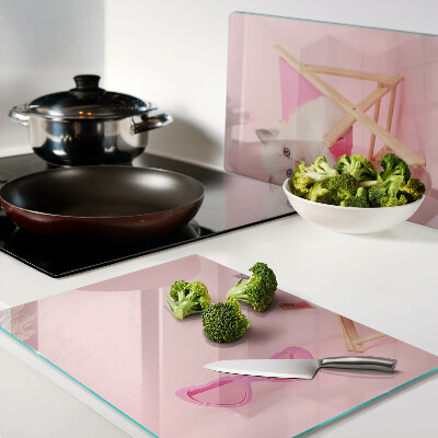 Tabla de cortar Un gatito en una tumbona sobre un fondo rosa.