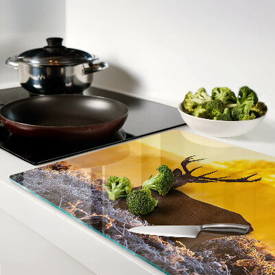 Tabla de cortar Un ciervo con el fondo de un paisaje matutino.