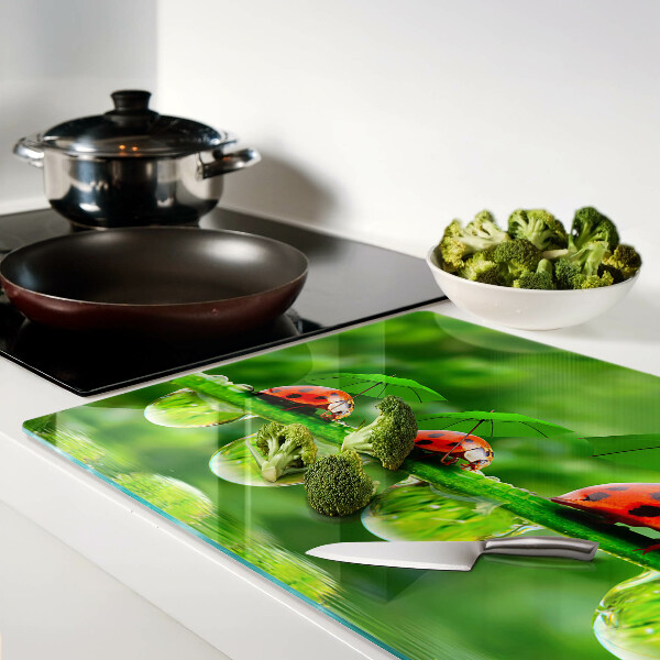 Tabla para cortar Mariquitas en hojas con gotas de agua.