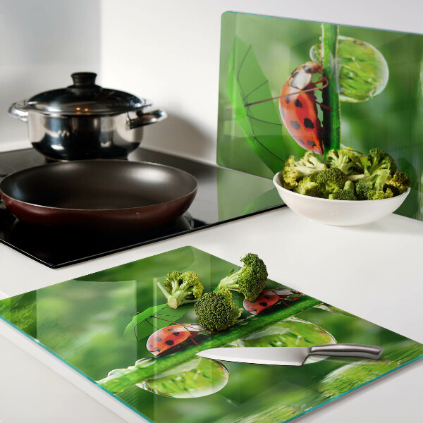 Tabla para cortar Mariquitas en hojas con gotas de agua.