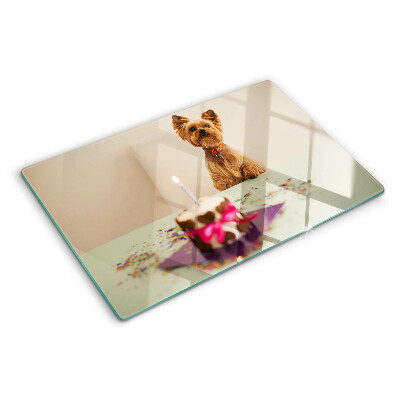 Tabla de cortar de cristal Un perro en la mesa con un pastel.