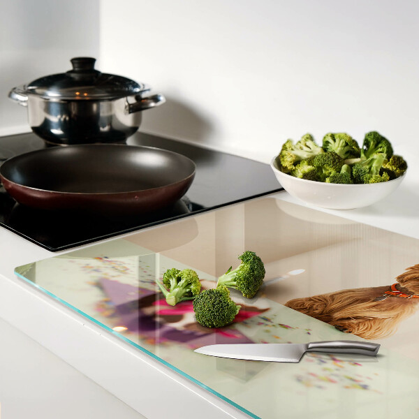 Tabla de cortar de cristal Un perro en la mesa con un pastel.