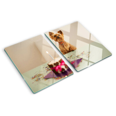 Tabla de cortar de cristal Un perro en la mesa con un pastel.