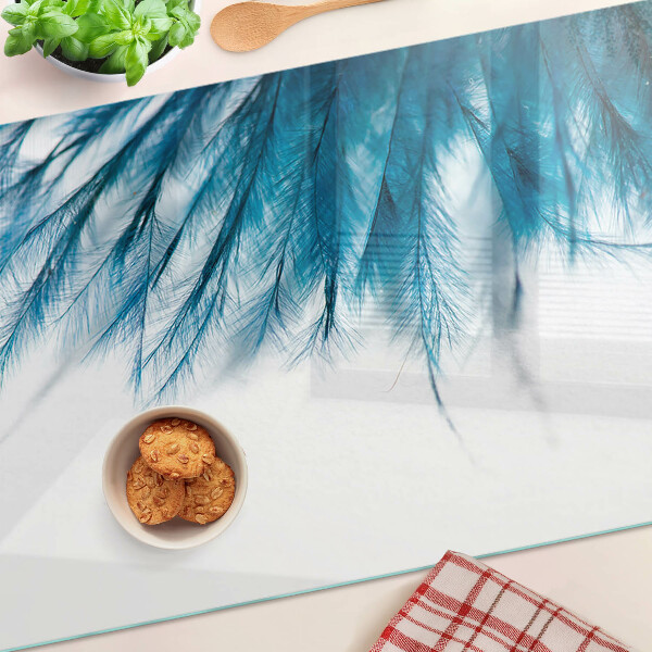 Tabla de cocina Plumas azules sobre fondo blanco.