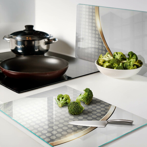 Tabla de cortar de cristal Una ola dorada sobre un fondo de puntos.