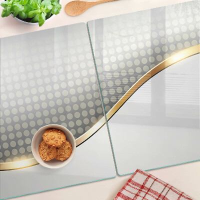 Tabla de cortar de cristal Una ola dorada sobre un fondo de puntos.