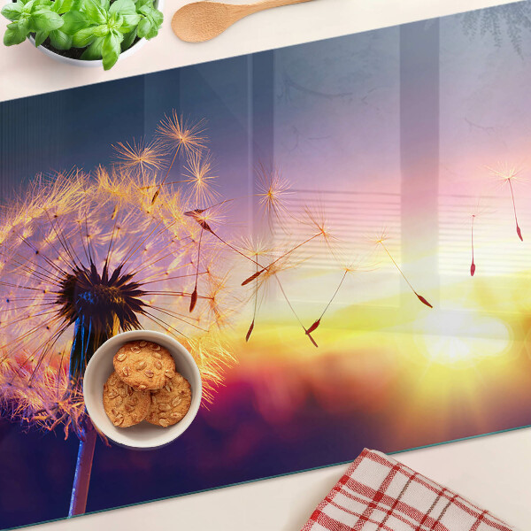 Tabla para cortar Dientes de león contra el fondo del atardecer