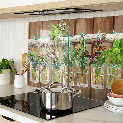 Tabla de cortar de cristal Hierbas en frascos sobre un fondo de madera.