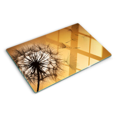 Tabla de cortar de cristal Dientes de león contra el fondo del atardecer