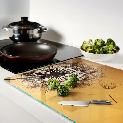 Tabla de cortar de cristal Dientes de león contra el fondo del atardecer