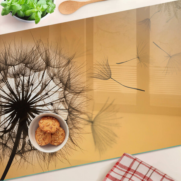 Tabla de cortar de cristal Dientes de león contra el fondo del atardecer