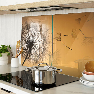 Tabla de cortar de cristal Dientes de león contra el fondo del atardecer