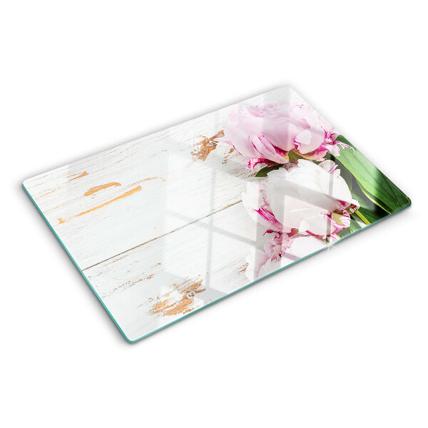 Tabla de cortar Flores de peonía sobre un fondo de madera.