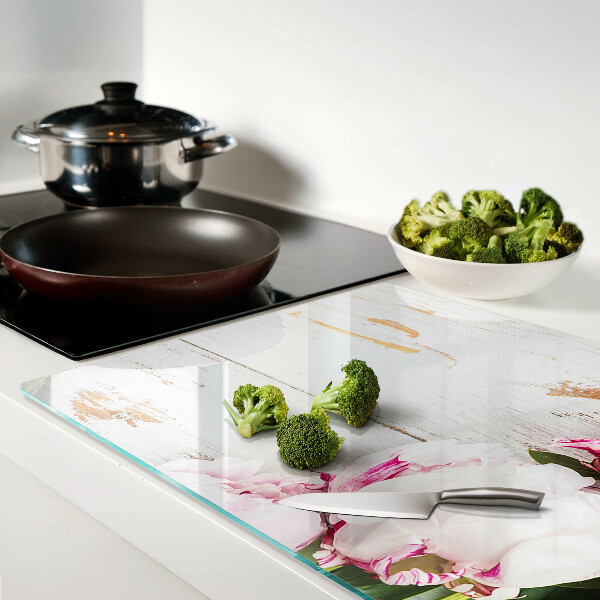 Tabla de cortar Flores de peonía sobre un fondo de madera.