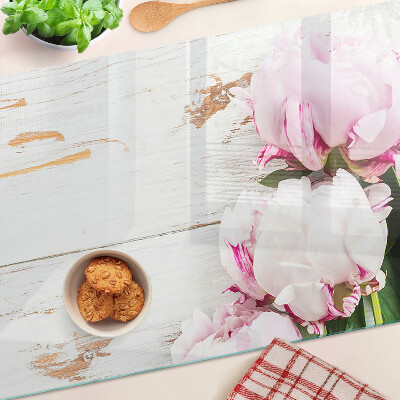 Tabla de cortar Flores de peonía sobre un fondo de madera.
