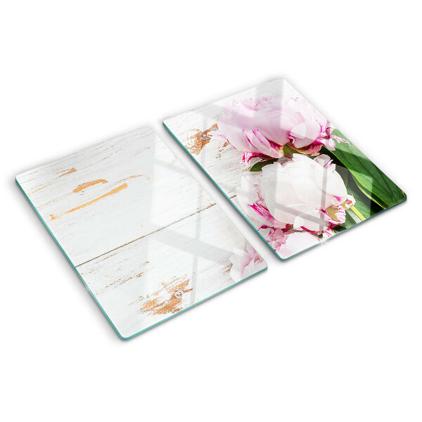 Tabla de cortar Flores de peonía sobre un fondo de madera.