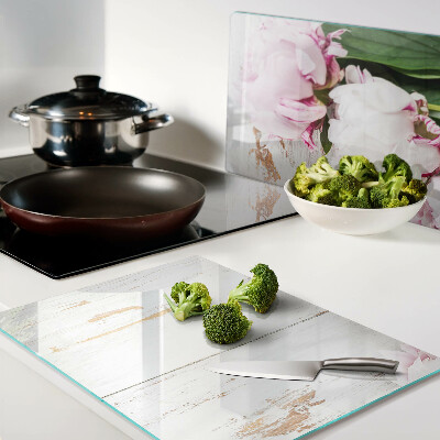 Tabla de cortar Flores de peonía sobre un fondo de madera.