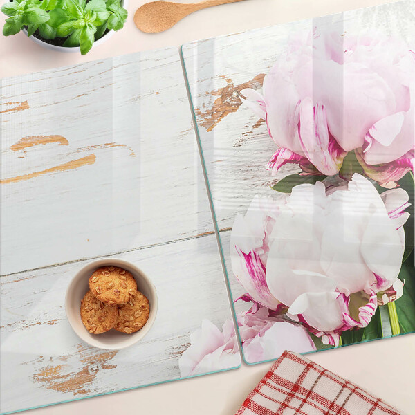 Tabla de cortar Flores de peonía sobre un fondo de madera.