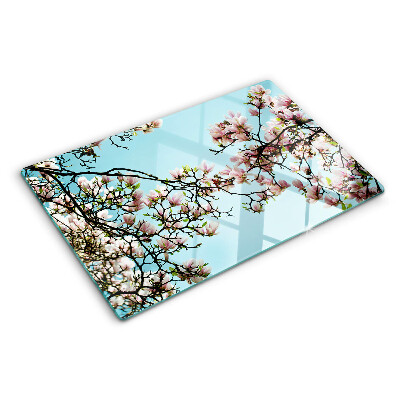 Tabla de cortar Flores de magnolia sobre fondo azul.