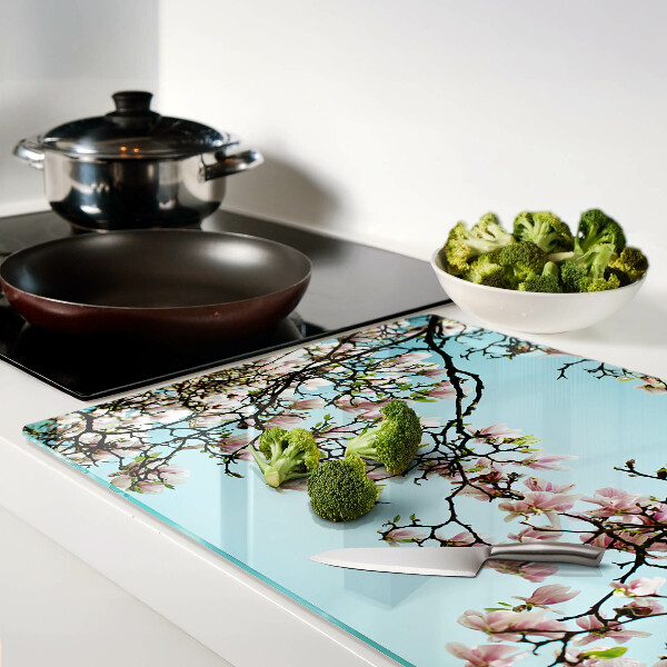 Tabla de cortar Flores de magnolia sobre fondo azul.