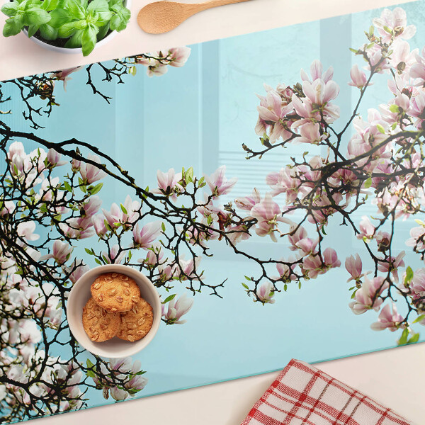 Tabla de cortar Flores de magnolia sobre fondo azul.