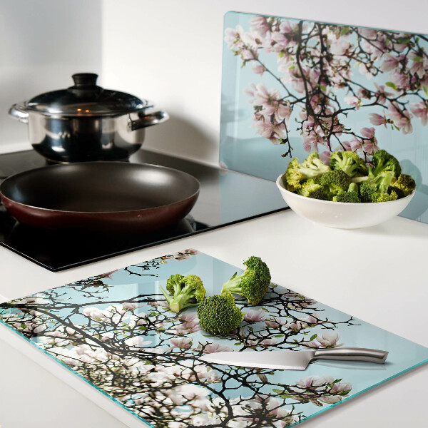 Tabla de cortar Flores de magnolia sobre fondo azul.