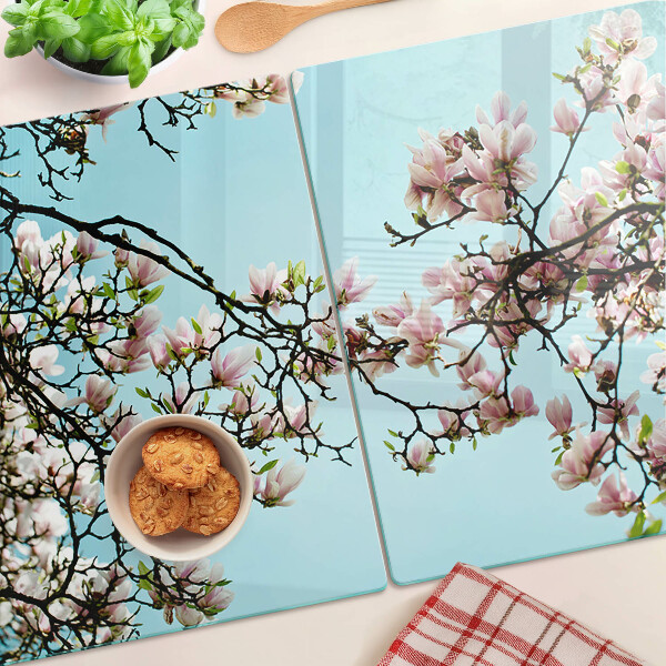 Tabla de cortar Flores de magnolia sobre fondo azul.