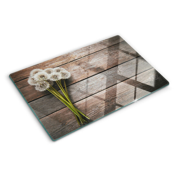 Tabla de cortar de cristal Flores de diente de león sobre un fondo de madera