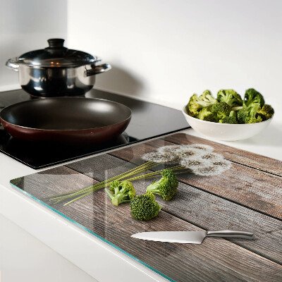 Tabla de cortar de cristal Flores de diente de león sobre un fondo de madera