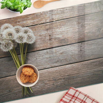 Tabla de cortar de cristal Flores de diente de león sobre un fondo de madera