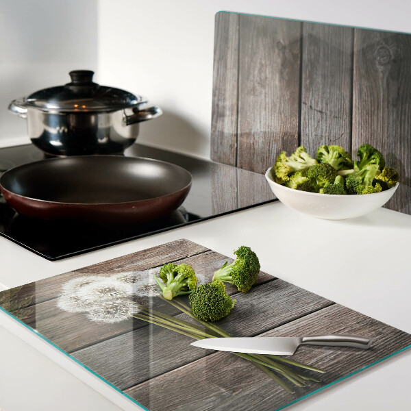 Tabla de cortar de cristal Flores de diente de león sobre un fondo de madera