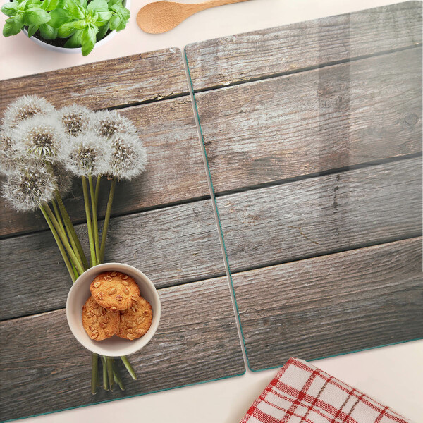 Tabla de cortar de cristal Flores de diente de león sobre un fondo de madera