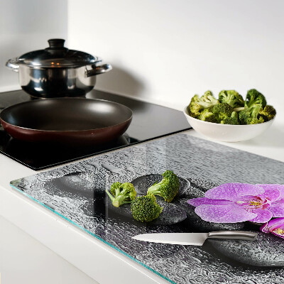 Tabla de cortar Flores y piedras contra el fondo del agua.